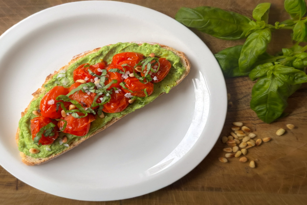 Toast met avocado-erwtenspread en geroosterde cherrytomaten 