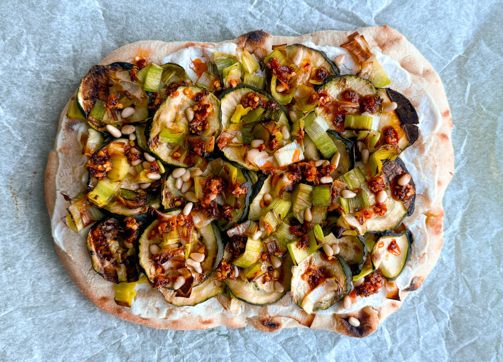 Pinsana met courgette, prei, citroen-ricotta, chili olie 